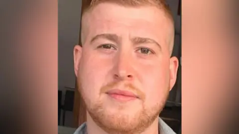 North Yorkshire Police A man with short facial hair, wearing a grey shirt, looks directly into the camera.