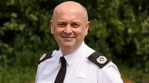 South Yorkshire Police A bald headed man in police uniform looks at the camera.