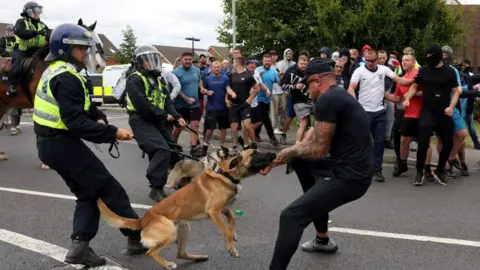 Reuters Police dog attacks protestors as crowd looks on