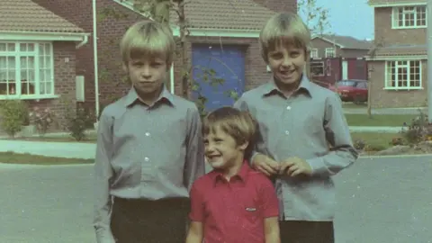 Steve Wyatt Steve Wyatt with his older twin brothers Rob and Mike smiling to camera. Circa 1980