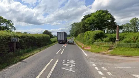 Google The current site of Staunton-on-Wye's war memorial, by an A438 junction, behind railings and above steps 