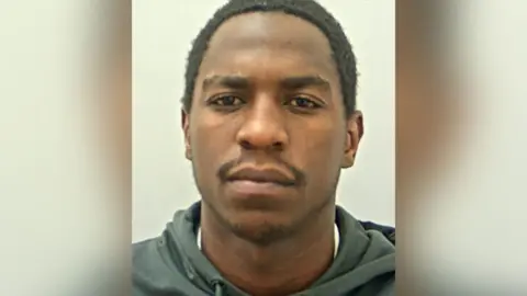 Lancashire Police Police custody shot of Bhekisani Matabiswana. He has a neutral expression and is wearing a dark green hoodie.