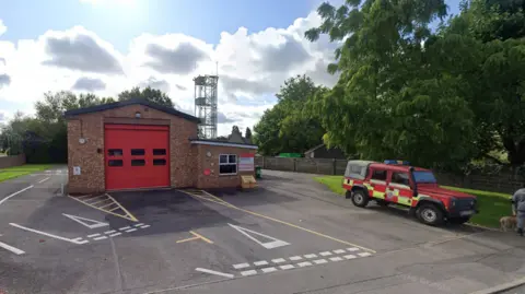 Google Google Street View of Maiden Newton Fire Station and a fire service Land Rover parked outside
