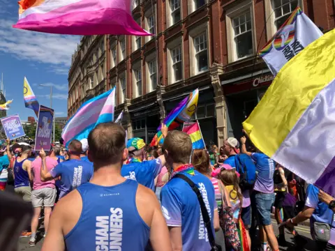 People joined the march with flags and boards to celebrate Notts Pride in Nottingham city centre on 25 July.