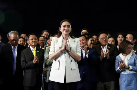 Chalinee Thirasupa / Reuters Thailand's new Prime Minister Paetongtarn Shinawatra smiles as he is surrounded by people during a news conference 