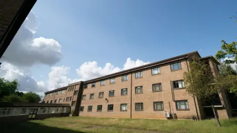 PA Media A general view of a large, three-storey block of flats at Wethersfield.