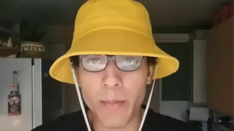 Youtube Nicholas Prosper seen wearing a yellow bucket hat.