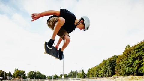 Teen boy skateboarding.