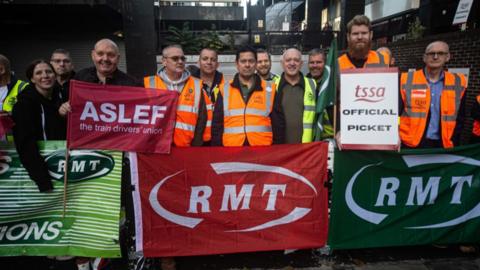 Members of RMT train drivers' union stand at a picket line
