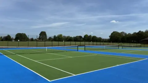 Three tennis courts coloured green and blue
