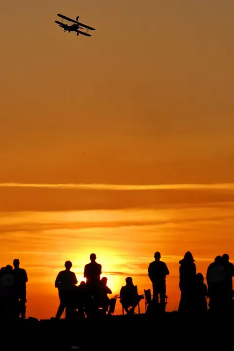 Andrew Carruthers  People watching a biplane at Ayr Festival of Flight, silhouetted against a sunset