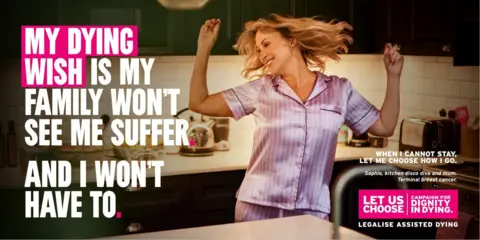 Dignity in Dying A woman in pink pyjamas dances in her kitchen. 
The advert features the words: "My dying wish is my family won't see me suffer. And I won't have to." The advert also says: "Sophie, kitchen disco div and mum. Terminal breast cancer."