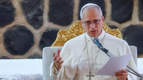 Pope Leo speaks at a podium. 