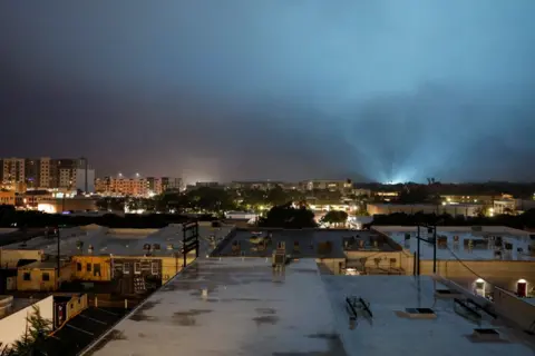 Marco Bello / Reuters The sky lights up as an electric installation is damaged, while Hurricane Milton approaches Sarasota, Florida, U.S., October 9, 2024.