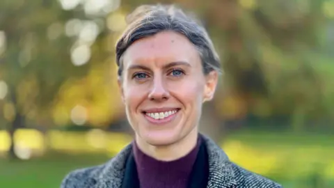 Jessica Toale stood in a green area smiling at the camera