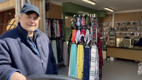 Andrew Turner/BBC Sal Nowman on his new stall at Great Yarmouth market