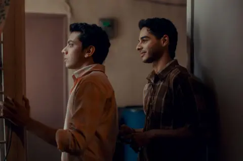Dharma Productions A still from Homebound shows the two leading actors in the film- Ishan Khatter and Vishal Jethwa - looking out of a window.