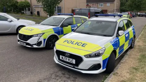 Two police cars parked on a street.