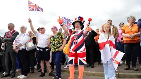 Pacemaker Spectators of the parade waving Union Jack flags and dressed up