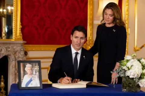 Reuters Canadian Prime Minister Justin Trudeau and his wife Sophie Trudeau sign a book of condolence at Lancaster House in London on 17 September