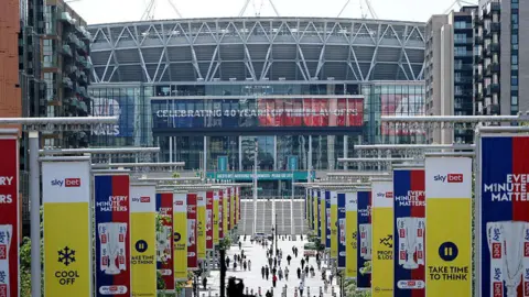 Getty Images A general view outside Wembley Stadium with banners along lampposts, with a banner that says "celebrating 40 years of the play-offs" on screen.