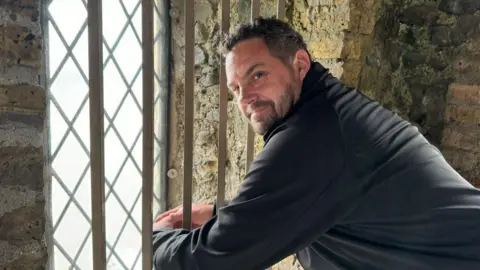 Jo Burn/BBC Volunteer Nathan Burney at the top of Reculver Towers