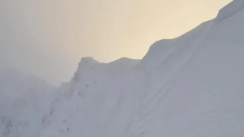 Llanberis Mountain Rescue Summit of Yr Wyddfa covered in snow and shrouded in cloud