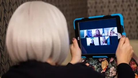 PA Media Woman using a tablet