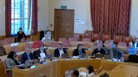 Peterborough City Council Councillor John Howard in a cabinet meeting sat with other members