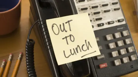 Getty Images A generic image of an "out to lunch" note stuck on a work phone