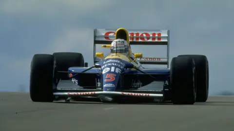 Getty Images Racing car mid-circuit with a blue body, with the words Renault Elf 4 on the front. The word Canon appears on the rear wing in red writing. Nigel Mansell's helmet is visible protruding from the cockpit. The car has very large black tyres.