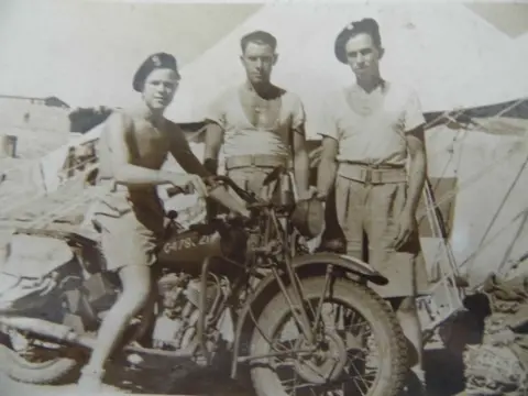 Sue Butler A shirtless Cpl Gasior of 2nd Polish Corps sits on his motorbike next to two other soldiers from the Polish Army 