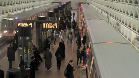 People wait for train at train station