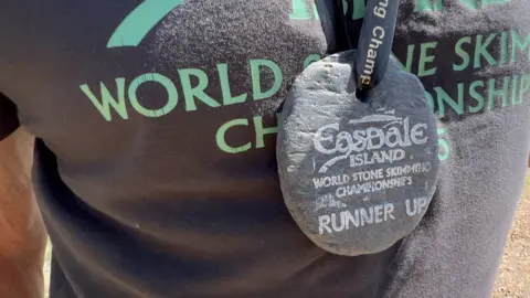 A runner-up's medal made of slate hangs around the neck of Gordon Couling.