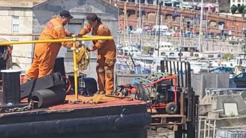 Worker using a pallet raised by a forklift truck at Ramsgate Harbour