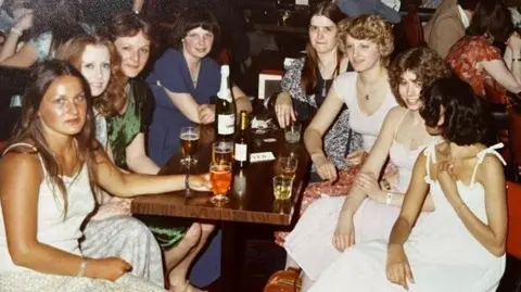 Sue Barrell A group of women around a table with drinks in 1978