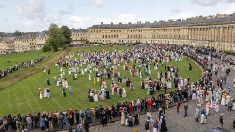 Jane Austen Festival People in regency era clothing are scattered across the lawn in front of Bath's Royal Crescent.