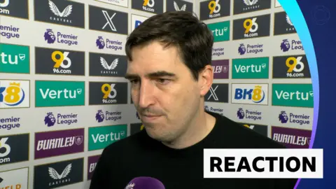 Andoni Iraola in post match interview standing against advertising boards 