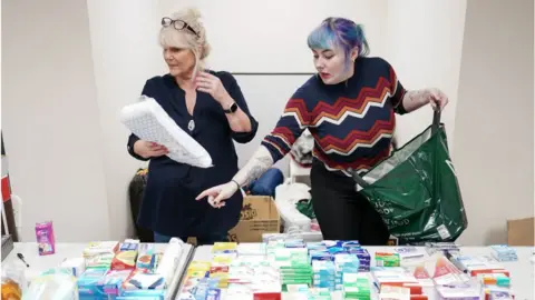 Getty Images Two volunteers assess donations in Hartlepool