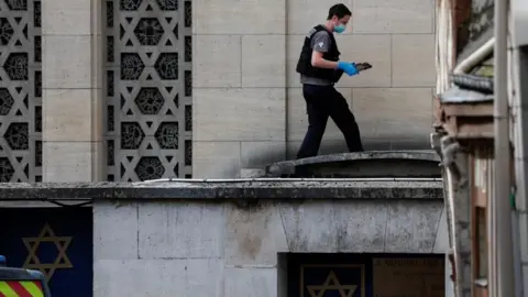 REUTERS/Gonzalo Fuentes A French police forensics member collects evidence after officers shot dead an armed man earlier who set fire to the city's synagogue in Rouen, France, May 17, 2024