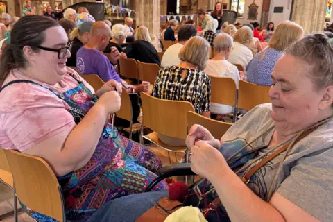 Chelmsford City Council Two women are sat together in the cathedral, knitting