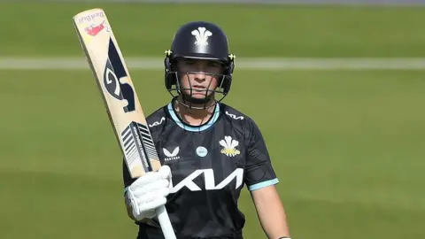 Surrey's Alice Capsey pictured holding up her bat