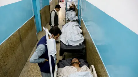 Reuters Injured men receive treatment in hospital