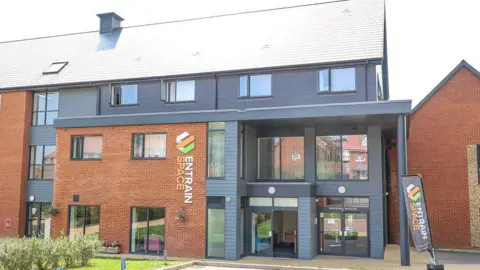 Entrain Space A residential building for flats in red brick with Entrain Space sign on the side