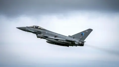 PA Media Grey jet aircraft with missiles under its wings pictured in an upward trajectory.