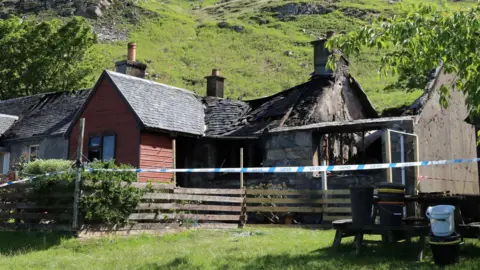 Peter Jolly/Northpix Part of the slate roof of the property has collapsed, while another section of the home has been gutted by the fire. There is police tape in front of the house.