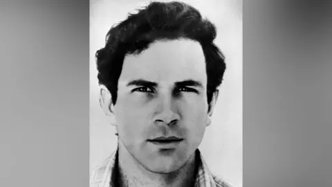A black and white portrait photograph of Yonatan Netanyahu. Blurred grey bars are either side of the photo. 
