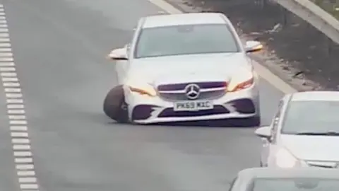 Car with badly damaged wheel on the M1.