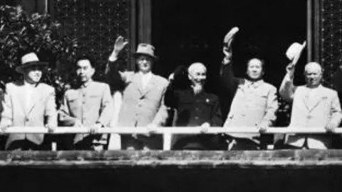 Getty Images is a black and white image showing a group of left to right, the head of the Korea Labor Party, Kim El Song, the first Prime Minister of the People's Republic