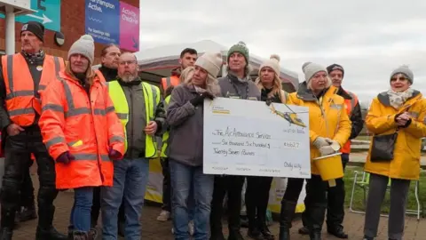 Chilly Willy A group of people hold up a large cheque for the Air Ambulance.